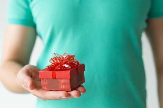 Closeup of guy holding small red gift box on palm