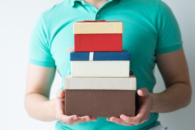 Closeup of guy holding stacked gift boxes