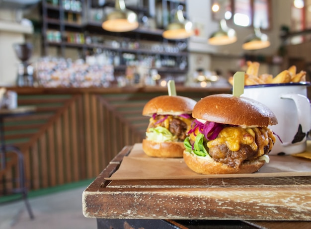 Closeup of hamburgers on a wooden tray with a blurred background