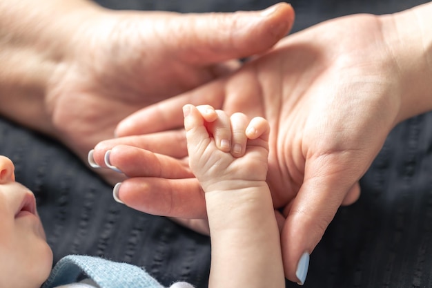 Foto gratuita primo piano le mani della mamma e della nonna del bambino