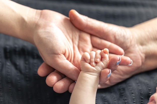 Free photo closeup the hands of the baby mom and grandmother