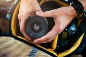 Free photo closeup of hands getting camera lens from bag