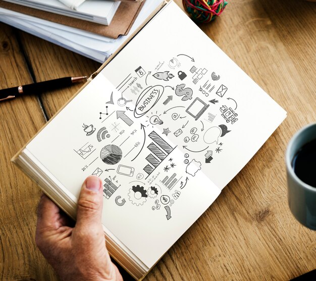 Closeup of hands holding open novel and coffee cup