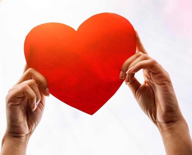 Closeup of hands holding paper heart