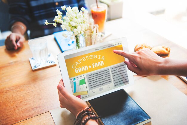 Closeup of hands holding tablet screen showing cafeteria review