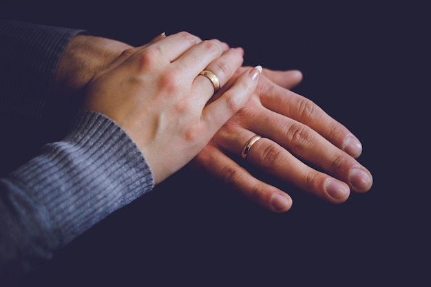 Closeup of the hands of husband and wife with rings