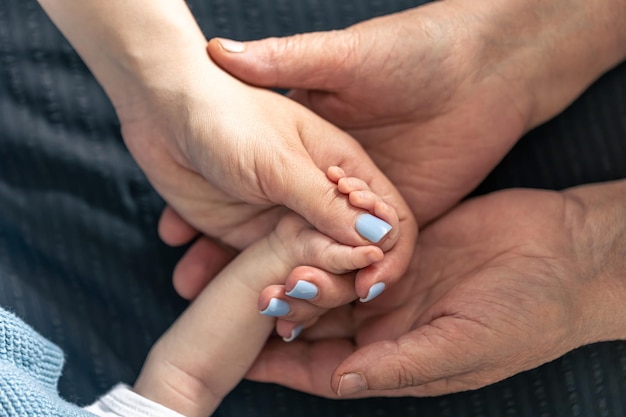 Бесплатное фото Крупным планом руки матери и бабушки ребенка