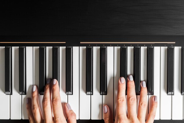 Крупным планом руки, играя фортепианную музыку и хобби концепции