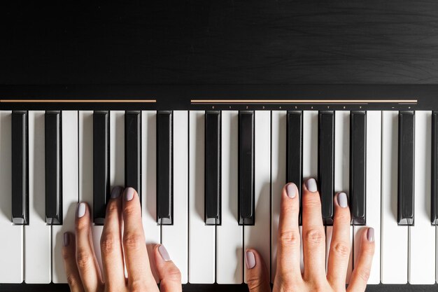 Closeup of hands playing piano music and hobby concept