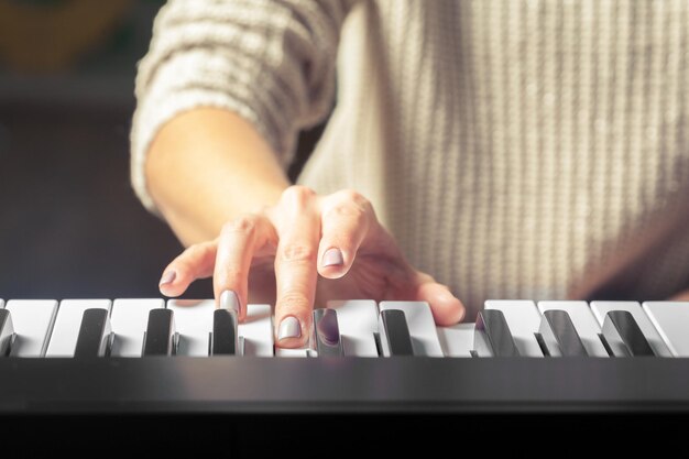 Closeup of hands playing piano music and hobby concept