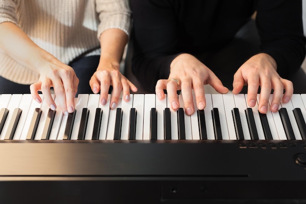 Closeup of hands playing piano music and hobby concept