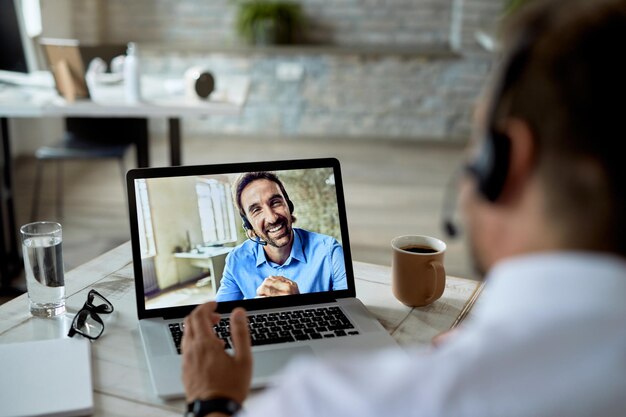 Closeup of happy entrepreneur having a video conference with his colleague