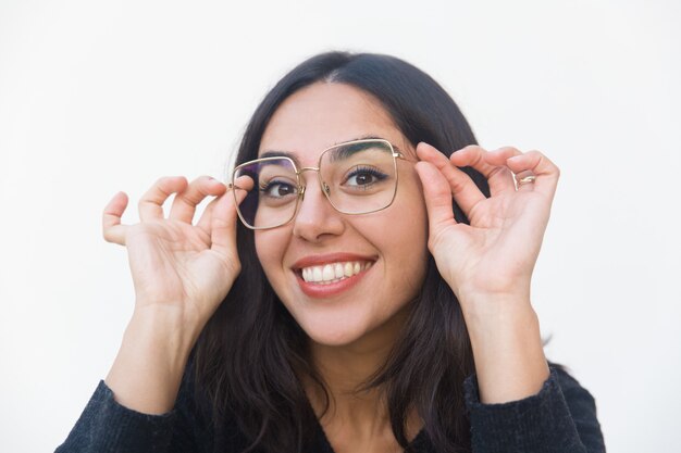 Closeup of happy joyful woman adjusting glasses