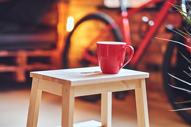 Closeup image of red coffee cup on a table.