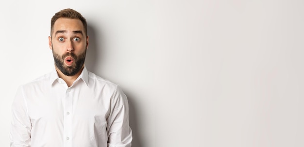 Free photo closeup of impressed man saying wow looking amazed at camera standing over white background