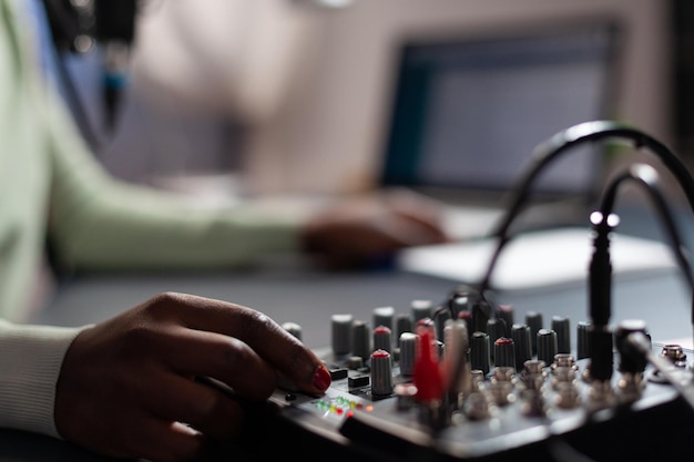 Free photo closeup of influencer woman checking sound of professional mixer while recording online vlog talking with subscribers using microphone. content creator filming video for social media. on air talk show