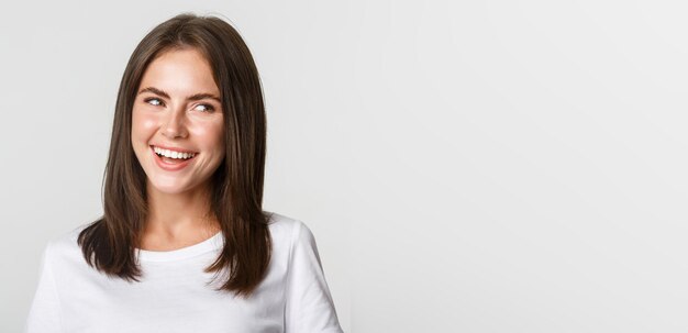 Closeup of joyful beautiful brunette girl looking right and laughing happy white background