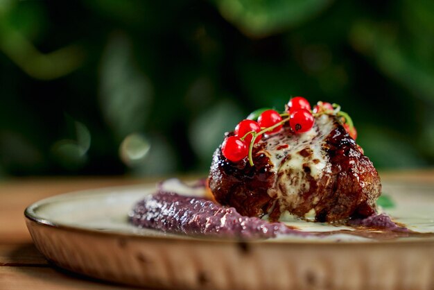 Closeup of juicy piece of kebab with cranberry and puree