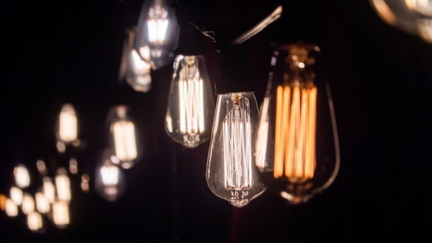 Closeup of lamps hanging from the wire in the evening