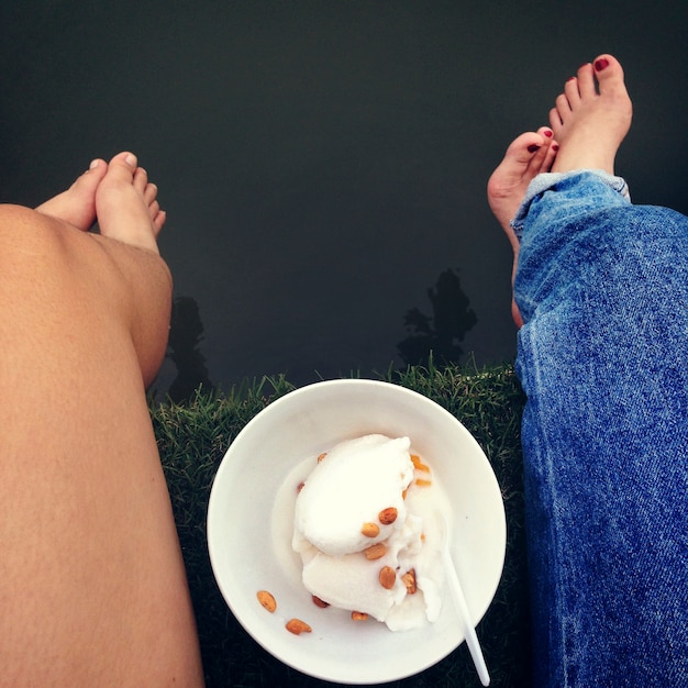 Closeup of legs with ice cream at waterside