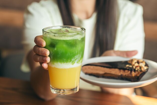 Closeup lemonade and chocolate cake in female hands