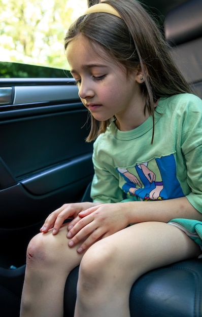 Free photo closeup of little girl holding her bruised injured damaged knee with her hands