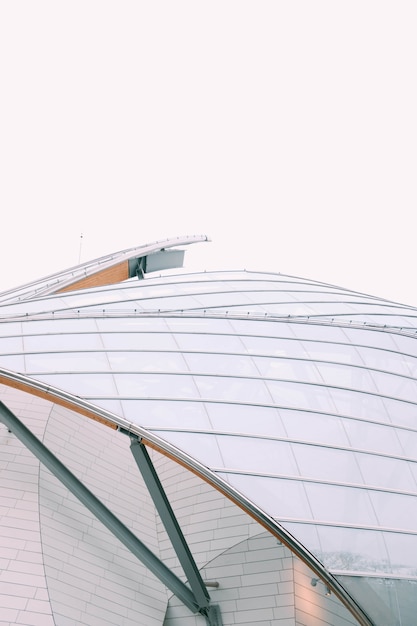 Closeup look  of a modern building with white glass windows under a grey sky