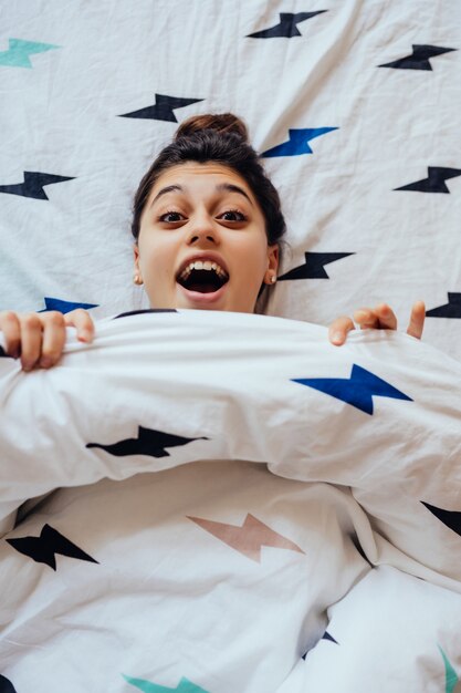 Closeup of Lovely young Woman Lies in Bed Covered with Blanket.