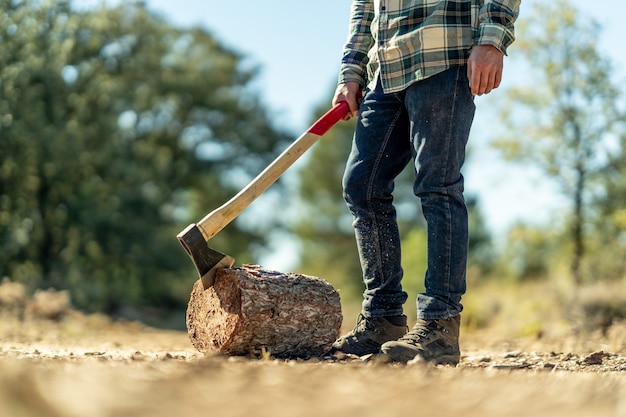 Closeup of a male cutting a tree trunk with an ax