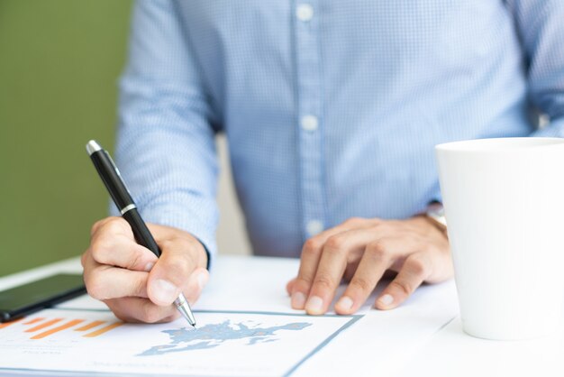 Closeup of male marketing expert analyzing bar chart