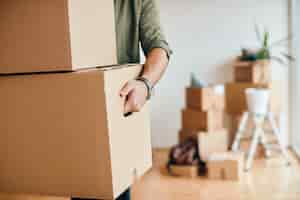 Free photo closeup of man carrying cardboard boxes while relocating into new apartment