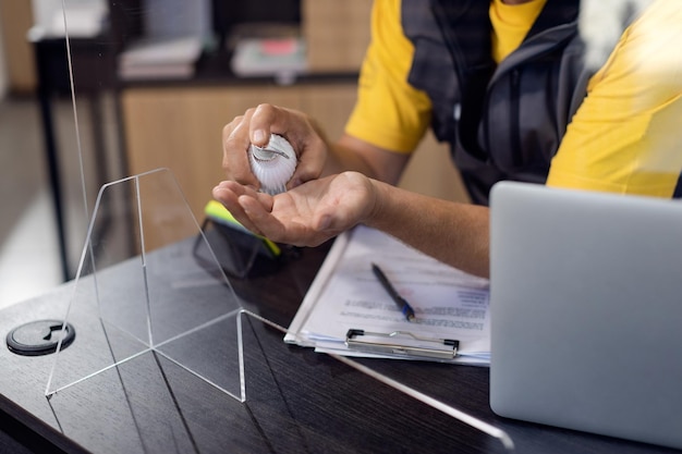 Foto gratuita primo piano dell'uomo che disinfetta le mani nell'ufficio dell'officina