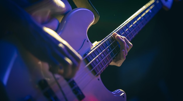 Closeup of a man playing the bass guitar