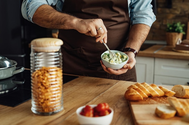 Free photo closeup of man using avocado while preparing healthy food in the kitchen