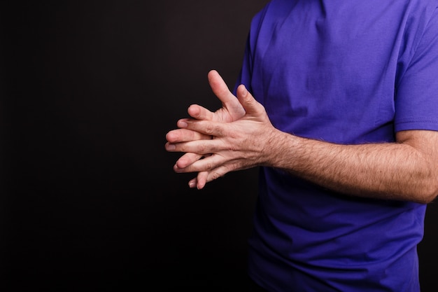 COVID-19-검정색 배경에 손 소독제를 사용하는 남자의 근접 촬영