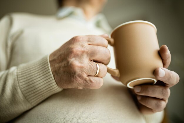 Closeup of mature man holding cup of coffee