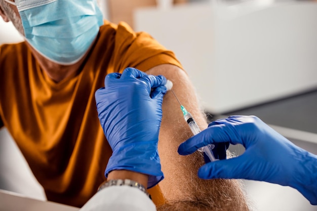 Closeup of mature patient getting vaccinated during COVID19 pandemic