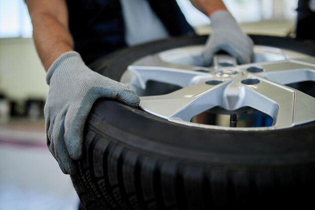 Closeup of a mechanic working with car tire in auto repair shop