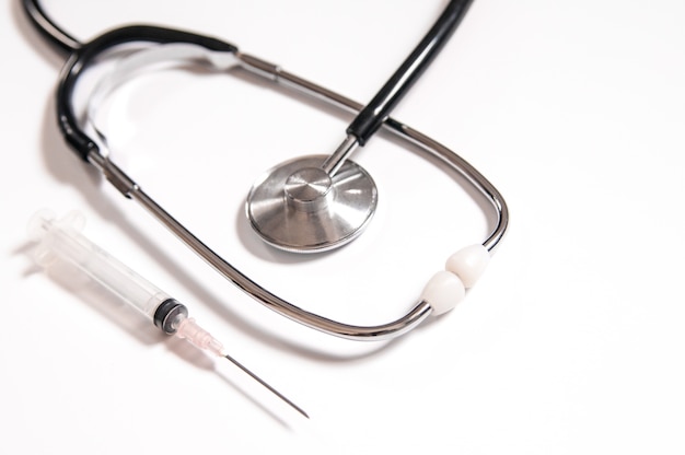 Free photo closeup of medicines, syringes and stethoscope. clean and bright health care image. plastic syringe with needle isolated on the white background