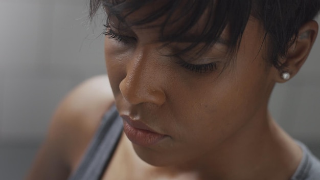 Closeup mixed race woman portrait during a rest in fitness workout looking at camera and deep breathing