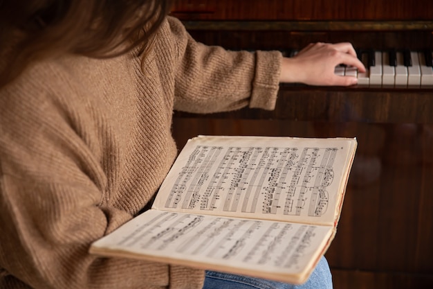 Foto gratuita primo piano delle note musicali in mani femminili