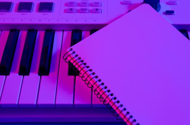 Free photo closeup notepad on musical keys in neon lighting