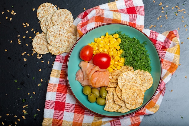 無料写真 テーブルの上のナプキンにサーモン、クラッカー、野菜とサラダのボウルのクローズアップ