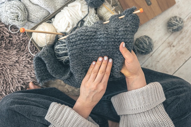 무료 사진 여성 손이 회색 양털 스웨터를 뜨개질하는 클로즈업