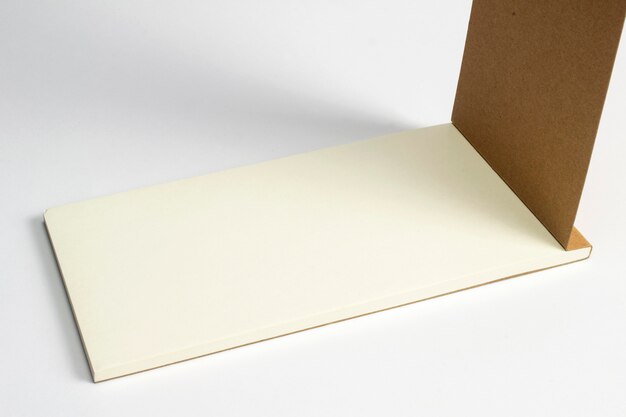 Closeup of opened diary with cardboard hardcover and blank pages isolated on white.