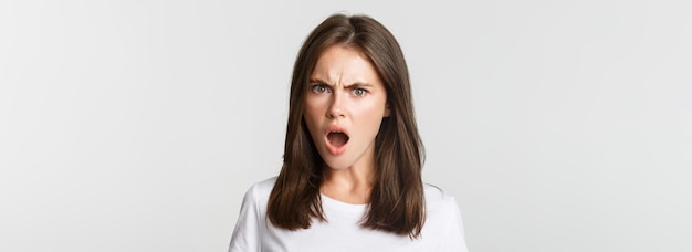 Closeup of outraged insulted young woman looking frustrated and frowning white background