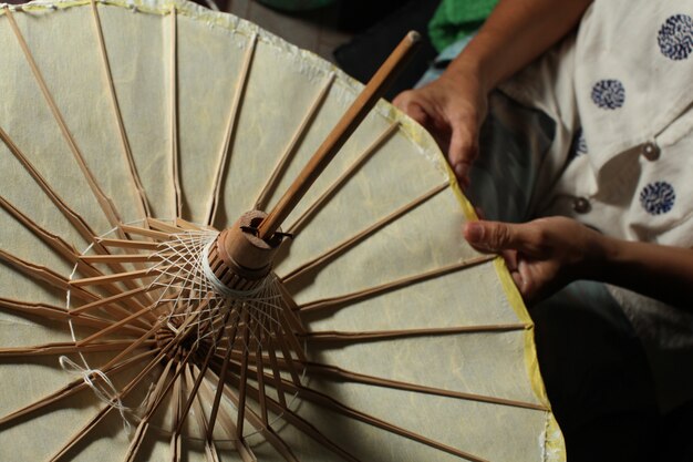 Closeup overhead shot of a person making a traditional Thai paper umbrella
