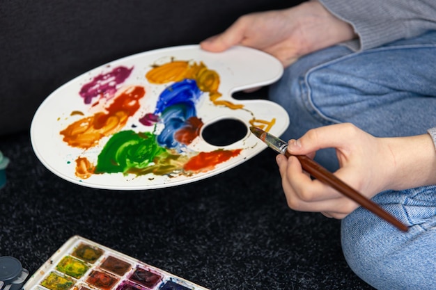 Closeup paint on a palette in female hands