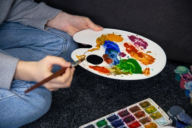 Closeup paint on a palette in female hands