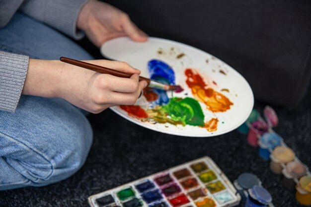 Closeup paint on a palette in female hands